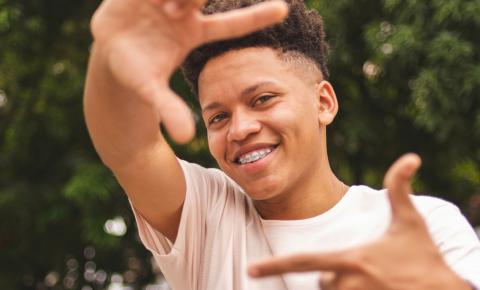 Black male high school student smiling and gesturing with hands